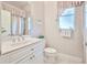 Bathroom featuring a white vanity, pastel wallpaper, and a shower and bath combination at 9091 Alexandria Dr, Weeki Wachee, FL 34613