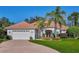 Charming single-story home boasts a red tile roof, brick driveway, and lush landscaping at 9091 Alexandria Dr, Weeki Wachee, FL 34613