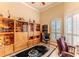 Stylish home office featuring built-in cabinets and a large window with shutter blinds at 9091 Alexandria Dr, Weeki Wachee, FL 34613