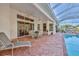 Spacious screened patio includes a dining area and lounge chair with access to the pool area at 9091 Alexandria Dr, Weeki Wachee, FL 34613