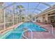 Inviting screened-in pool area featuring a spa and brick-paved patio for outdoor relaxation at 9091 Alexandria Dr, Weeki Wachee, FL 34613