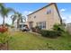 Exterior view of the home with a patio, green grass, and lush landscaping at 18819 Sunterra Dr, Land O Lakes, FL 34638