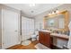 Clean bathroom with white shower curtain, wooden vanity, and granite countertop at 18819 Sunterra Dr, Land O Lakes, FL 34638