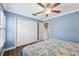 Bedroom with blue walls, wood floors, and a double door closet at 18819 Sunterra Dr, Land O Lakes, FL 34638