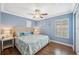 Bedroom featuring wood flooring, a ceiling fan, and two shuttered windows at 18819 Sunterra Dr, Land O Lakes, FL 34638