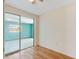 Bedroom with wood floors and access to the outdoor patio via sliding glass doors at 10841 Piccadilly Rd, Port Richey, FL 34668