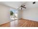 Bright living room with wood floors, ceiling fan, and sliding glass doors to the backyard at 10841 Piccadilly Rd, Port Richey, FL 34668
