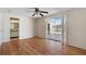Spacious living room with sliding glass door, light wood flooring, and ceiling fan at 10841 Piccadilly Rd, Port Richey, FL 34668