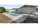Pool with a concrete perimeter, adjacent to the house with white walls and a green landscape at 10841 Piccadilly Rd, Port Richey, FL 34668