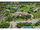 Aerial view features a community clubhouse, pool, and the surrounding golf course and residences at 11008 Torrey Pines Ct, Hudson, FL 34667