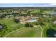 Aerial view of a community clubhouse with a pool, golf course, and surrounding neighborhood at 11008 Torrey Pines Ct, Hudson, FL 34667
