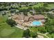 Aerial view of a community clubhouse with a large pool, patio area, and lush landscaping at 11008 Torrey Pines Ct, Hudson, FL 34667