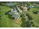 An aerial view showcases community amenities, tennis courts, bocce ball, and lush landscaping at 11008 Torrey Pines Ct, Hudson, FL 34667