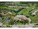 An aerial view of community clubhouse, pool, golf course, and a scenic pond at 11008 Torrey Pines Ct, Hudson, FL 34667