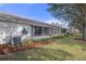 Charming back exterior featuring a screen enclosed patio along the back of the home with well-maintained lawn at 11008 Torrey Pines Ct, Hudson, FL 34667