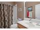 Well-lit bathroom featuring a shower-tub combo with curtain, a single sink vanity, and a large mirror at 11008 Torrey Pines Ct, Hudson, FL 34667