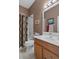 Well-lit bathroom featuring a shower-tub combo with curtain, a single sink vanity, and a large mirror at 11008 Torrey Pines Ct, Hudson, FL 34667