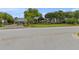A view of the clubhouse with lush landscaping and golf carts parked nearby, inviting relaxation and recreation at 11008 Torrey Pines Ct, Hudson, FL 34667