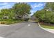 An exterior image of the clubhouse entrance, showcasing a well-maintained driveway and lush greenery at 11008 Torrey Pines Ct, Hudson, FL 34667