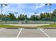 View of the tennis courts with parking, offering recreational opportunities in a well-maintained sports area at 11008 Torrey Pines Ct, Hudson, FL 34667