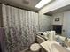 Clean bathroom with a patterned shower curtain, white fixtures and a large mirror at 12408 Eagleswood Dr # B, Hudson, FL 34667
