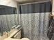 Bathroom featuring a gray and white patterned shower curtain and gray towels at 12408 Eagleswood Dr # B, Hudson, FL 34667