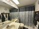 Bathroom featuring a gray and white patterned shower curtain, gray towels, and decorative mirror at 12408 Eagleswood Dr # B, Hudson, FL 34667