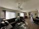 Living room showcasing wood laminate floors, fan, comfortable seating, and ample natural light at 12408 Eagleswood Dr # B, Hudson, FL 34667