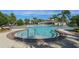 A spacious community pool offers a jacuzzi and plenty of seating areas near a clubhouse and shade pavilions at 13357 Marble Sands Ct, Hudson, FL 34669