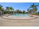 A zero-entry community pool offers a splash pad area and is surrounded by palm trees and lounge chairs at 13357 Marble Sands Ct, Hudson, FL 34669