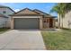 Charming single-story home featuring a two-car garage, well-maintained lawn, and welcoming front entrance at 13357 Marble Sands Ct, Hudson, FL 34669
