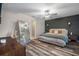 Serene main bedroom with dark accent wall, wood-look floors, ceiling fan, and ensuite bathroom at 13357 Marble Sands Ct, Hudson, FL 34669