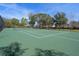 Well-maintained tennis court with clear markings, surrounding fence and benches for a great outdoor sports experience at 13357 Marble Sands Ct, Hudson, FL 34669