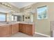 Bathroom featuring a dual sink vanity, a large mirror with lighting, and a window for natural light at 1442 Lenton Rose Ct, Trinity, FL 34655