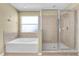 Bathroom features a soaking tub with tile surround and a glass-enclosed shower stall at 1442 Lenton Rose Ct, Trinity, FL 34655