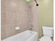 Bathroom featuring a shower and tub combination, along with a toilet and tile surround at 1442 Lenton Rose Ct, Trinity, FL 34655