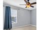 Bedroom with a ceiling fan and a window with blue curtains, creating a cozy ambiance at 1442 Lenton Rose Ct, Trinity, FL 34655