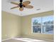 Bedroom with a ceiling fan, a large window offering natural light, and neutral color palette at 1442 Lenton Rose Ct, Trinity, FL 34655