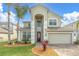 Two-story home featuring a well-manicured lawn, tall arched entry, and attached two car garage at 1442 Lenton Rose Ct, Trinity, FL 34655
