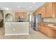 Bright kitchen featuring wood cabinets, a center island, granite counters and stainless steel appliances at 1442 Lenton Rose Ct, Trinity, FL 34655