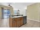 Kitchen island with a sink and dishwasher overlooks sliding glass doors to the outdoor area at 1442 Lenton Rose Ct, Trinity, FL 34655