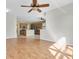 Spacious living room with wood floors, a ceiling fan and a kitchen in the background at 1442 Lenton Rose Ct, Trinity, FL 34655