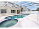 Sparkling screened-in pool and spa with clear blue water, and a neutral-colored patio, perfect for entertaining at 1442 Lenton Rose Ct, Trinity, FL 34655