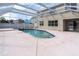 Screened-in pool with a hot tub and a spacious concrete deck, perfect for enjoying the outdoors at 1442 Lenton Rose Ct, Trinity, FL 34655