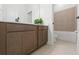 Bathroom vanity with double sink and white countertop with view of shower-tub combo with tan ceramic tile at 14421 Nonna Sky Drive Dr, Spring Hill, FL 34609