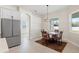Bright breakfast nook with modern light fixture, adjacent to kitchen with stainless steel refrigerator at 14421 Nonna Sky Drive Dr, Spring Hill, FL 34609