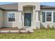 Elegant entryway with columns and a stylish green front door and shutters at 14421 Nonna Sky Drive Dr, Spring Hill, FL 34609