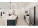 Bright kitchen boasts stainless appliances, pendant lighting, and an expansive center island with a sink at 14421 Nonna Sky Drive Dr, Spring Hill, FL 34609
