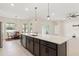 Spacious kitchen island with sink overlooks dining area, windows, and sliding glass doors to the outdoors at 14421 Nonna Sky Drive Dr, Spring Hill, FL 34609