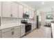Modern kitchen featuring stainless steel appliances, white cabinets, and sleek countertops at 14421 Nonna Sky Drive Dr, Spring Hill, FL 34609